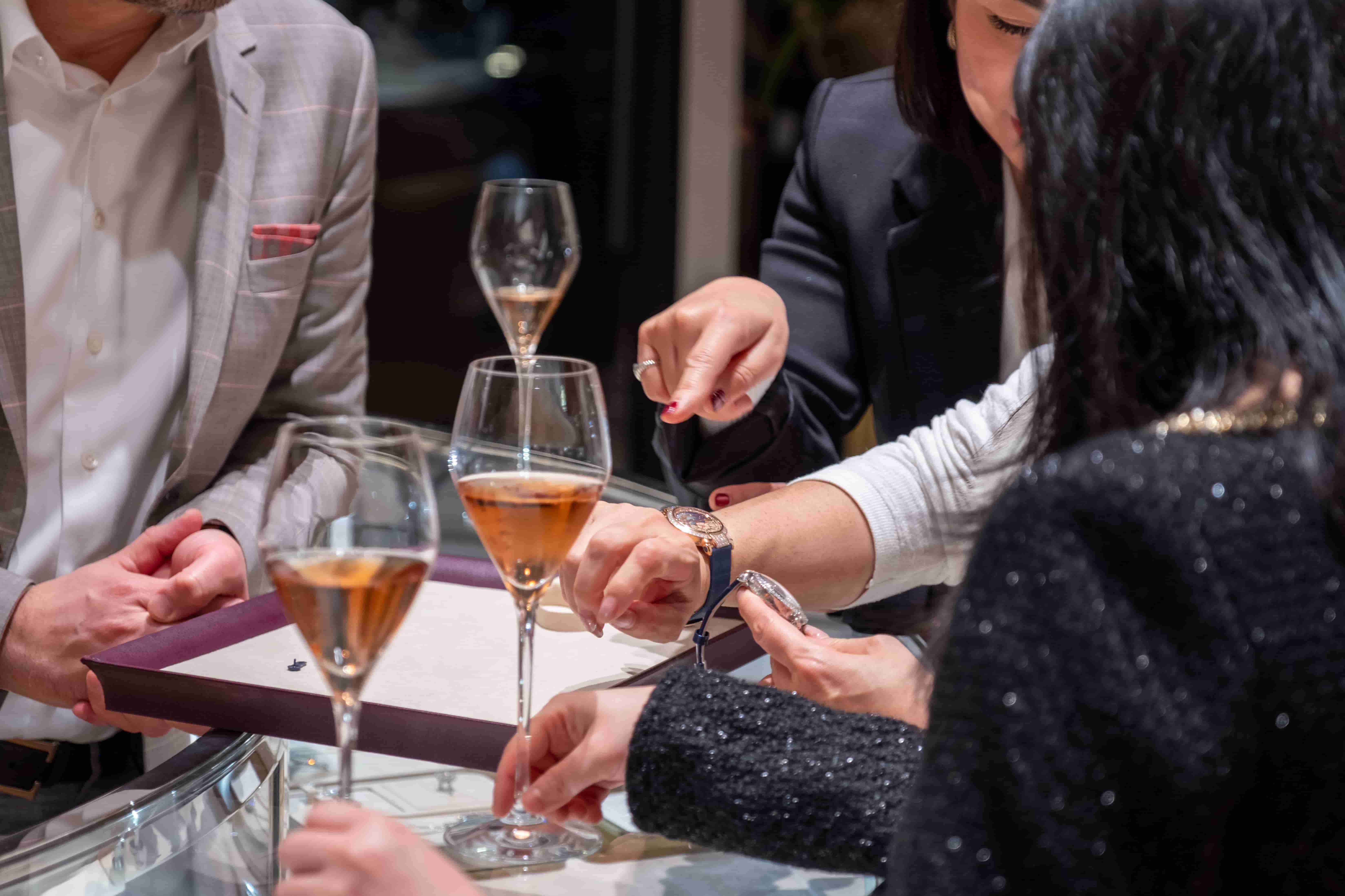 Guests enjoying rosé champagne and discussing Chopard luxury watches during an exclusive in-store celebration.