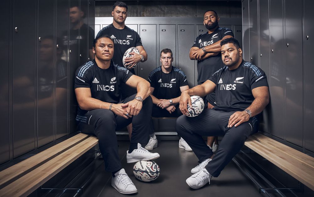 New zealand rugby players pose in a locker.