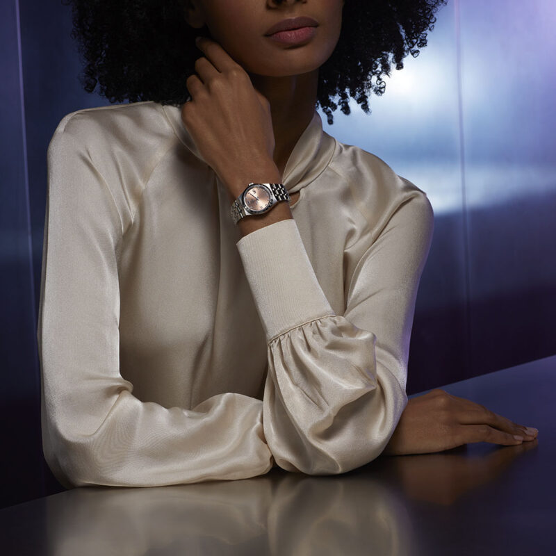 A woman in a white shirt (Product Name: M28500-0009) is posing for a photo.