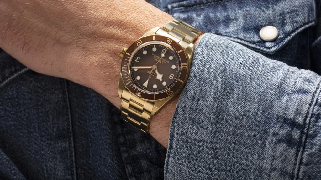 A man is wearing a gold watch on his wrist.