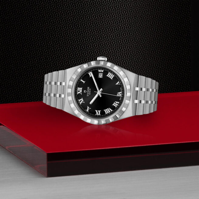 A M28500-0003 oyster watch with roman numerals on a red background.