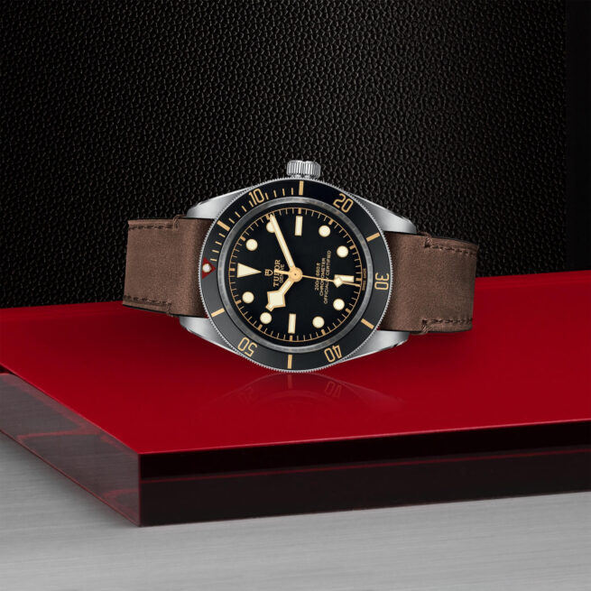 A M79030N-0002 watch on a red table.