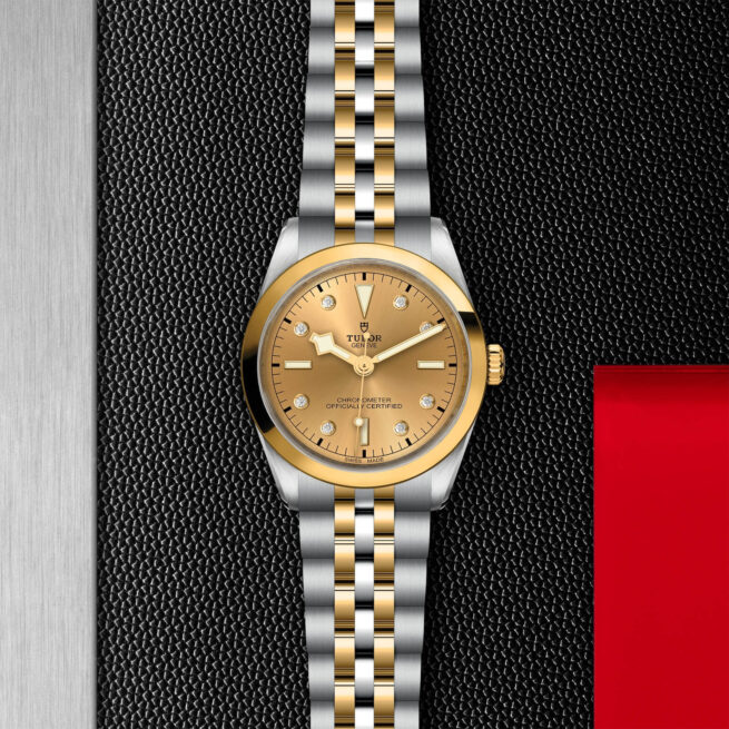 A M79643-0008 watch with a yellow dial on a black background.