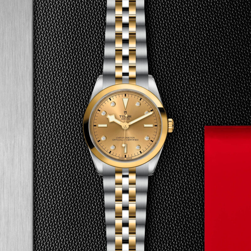 A M79643-0008 watch with a yellow dial on a black background.