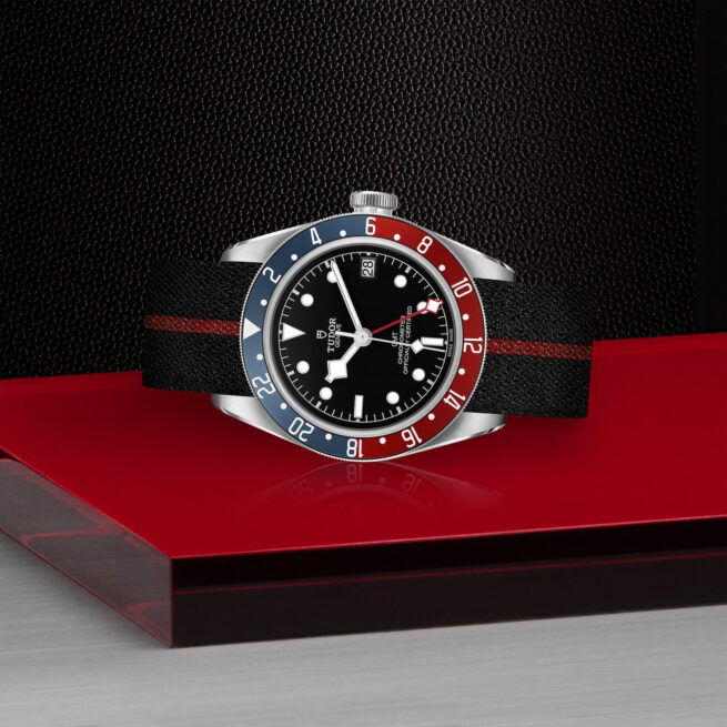 A M79830RB-0003 watch on a red and blue background.