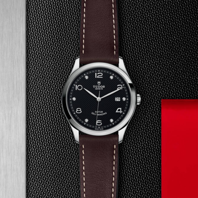 A M91650-0009 with a brown leather strap on a black background.