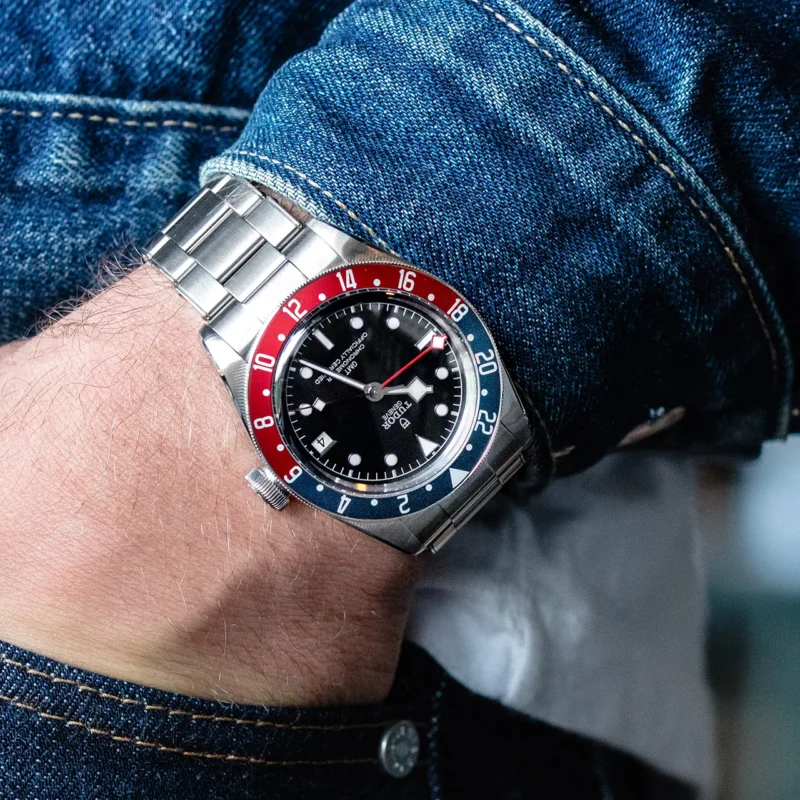 A man wearing a M79830RB-0001 with a red and blue bezel.