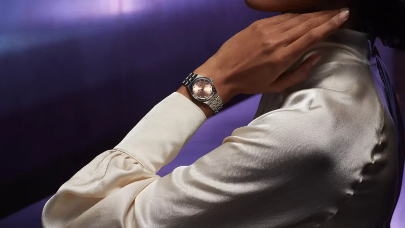 A woman is posing with a watch on her wrist.