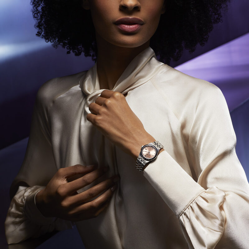 A woman in a white shirt is posing with a M28600-0009.