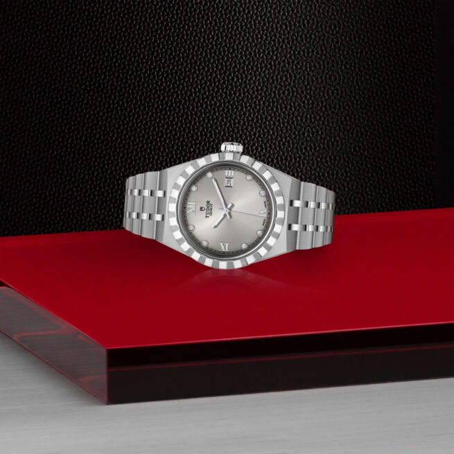 A M28300-0002 watch with diamonds on a red table.