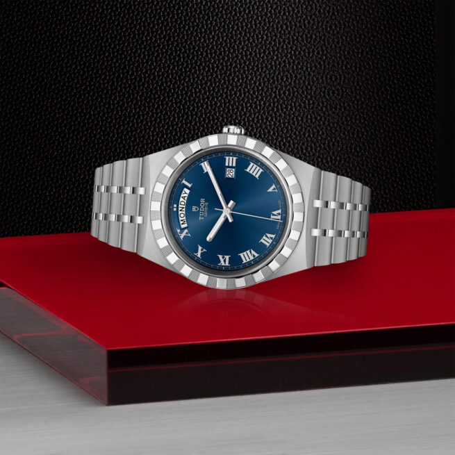 A M28600-0005 with a blue dial sitting on a red table.