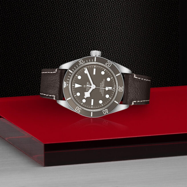 A M79010SG-0001 watch on a red table.
