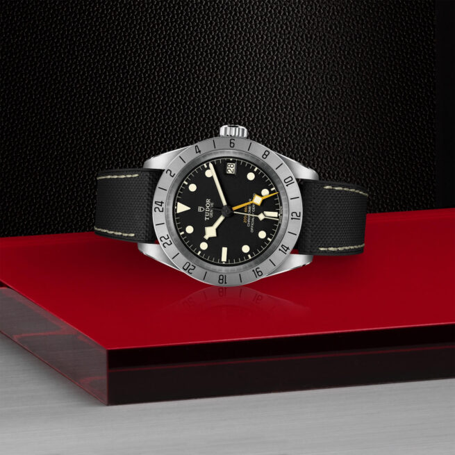 The M79470-0003 watch on a red table.