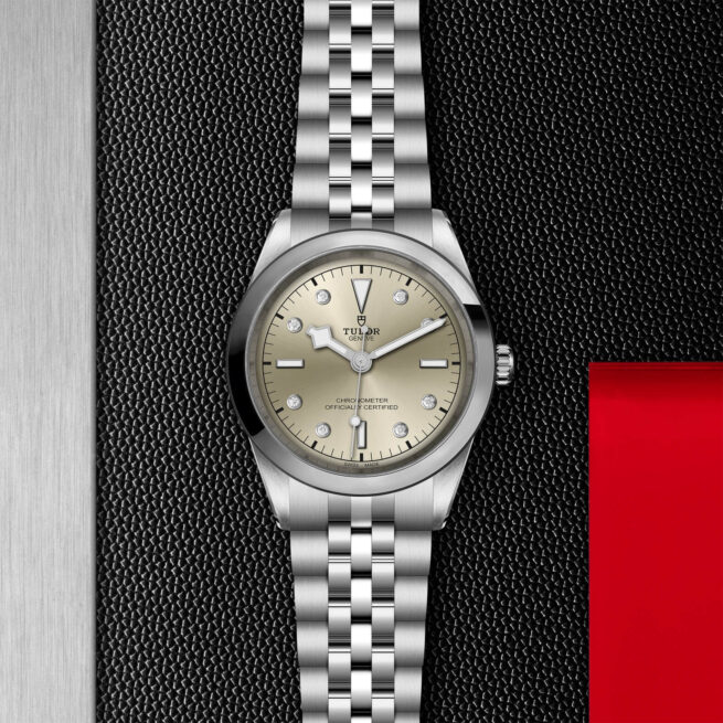 A M79680-0006 watch with a silver dial on a black background.