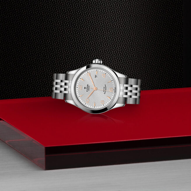 A M91350-0001 watch sitting on a red table.