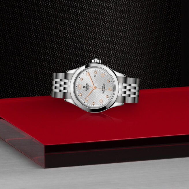 A M91350-0003 watch sitting on a red table.