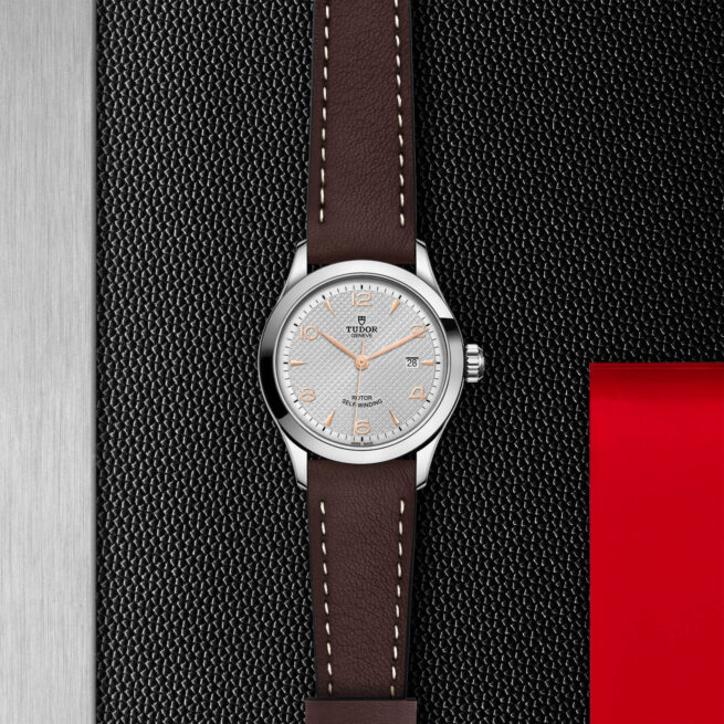 A M91350-0006 with a brown leather strap on a black background.