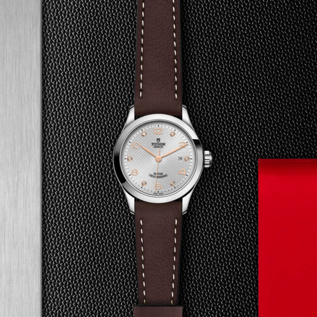 A M91350-0007 with a brown leather strap on a red background.