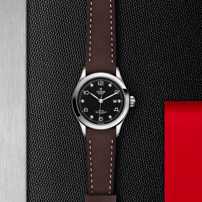 A black and brown M91350-0009 on a black leather strap.