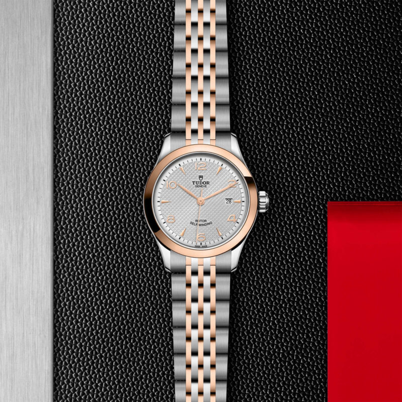 M91351-0001 ladies' watch on a red background.