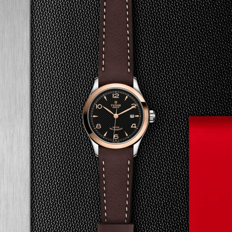 A black and brown M91351-0007 on a black leather strap.