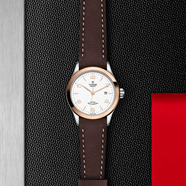 A M91351-0010 with a brown leather strap on a black background.