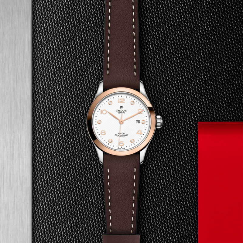 A M91351-0012 with a brown leather strap on a black background.