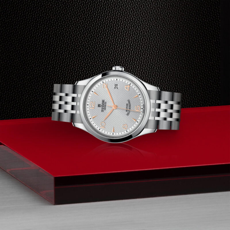 A M91450-0001 watch sitting on a red table.