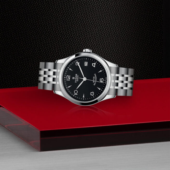 A M91450-0002 watch on a red surface.