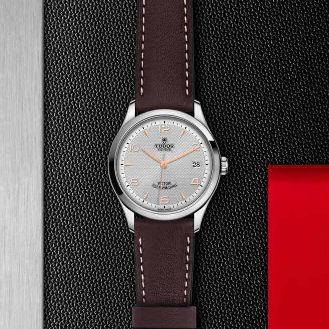 A watch with a brown leather strap on a red background. Product Name: M91450-0006