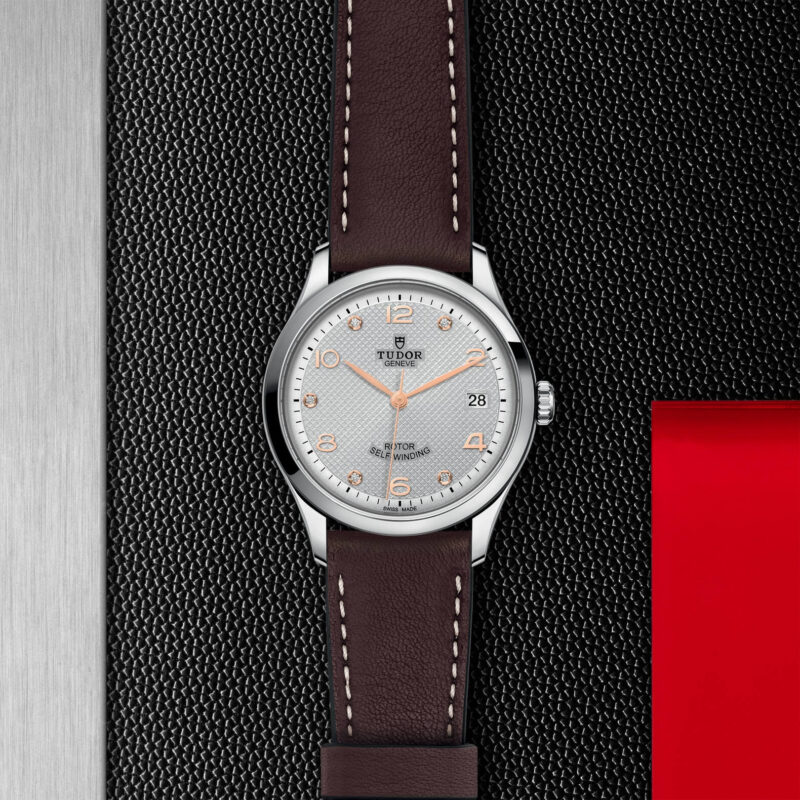 A watch with a brown leather strap on a red background. Product Name: M91450-0007