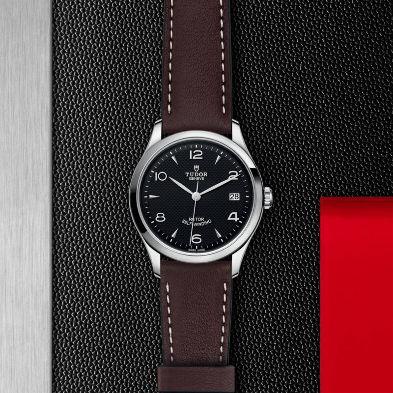 A M91450-0008 with a brown leather strap on a black background.