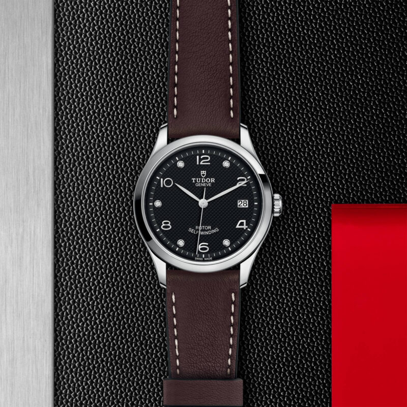 A M91450-0009 with a brown leather strap on a black background.
