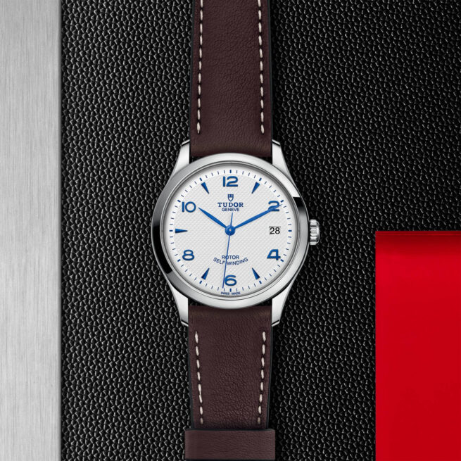 A white and brown M91450-0010 on a red leather strap.