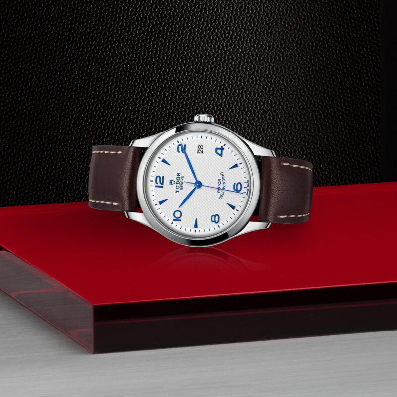 A M91450-0010 watch on a red surface.