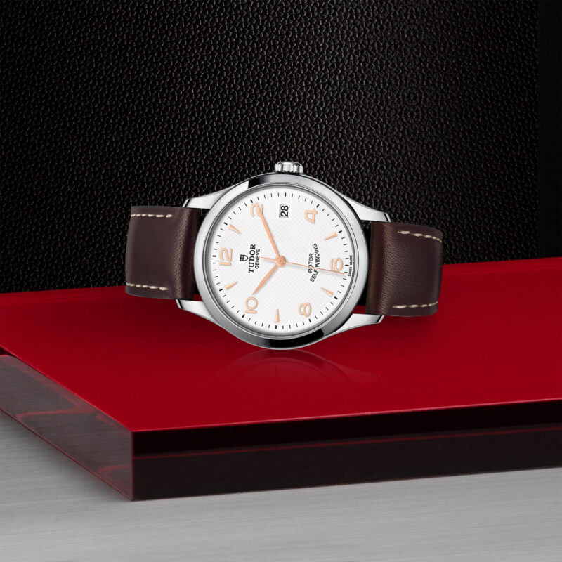 A M91450-0012 watch on a red surface.