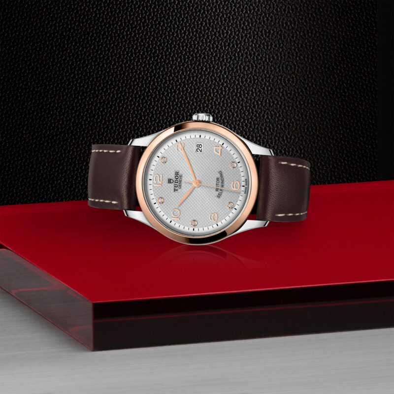 A M91451-0006 watch on a red surface.