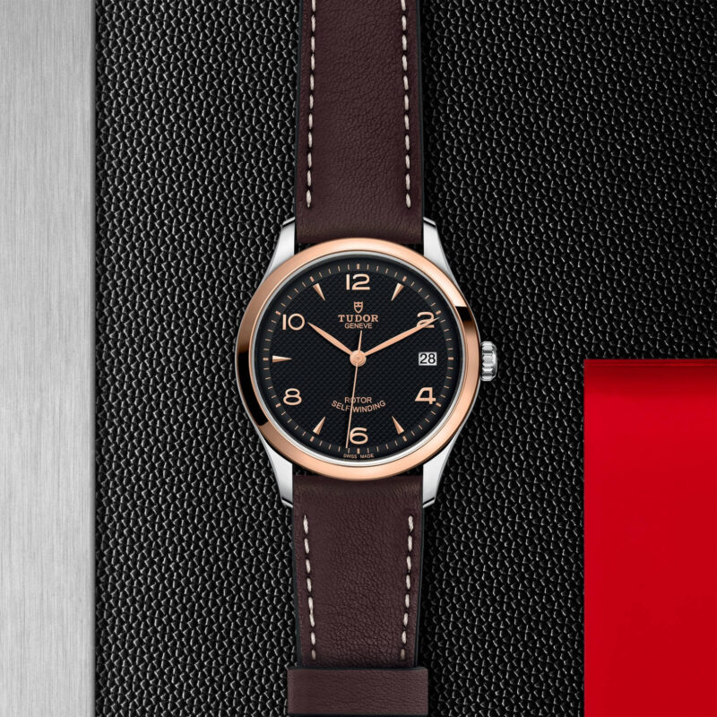 A watch with a brown leather strap (M91451-0007) on a red background.