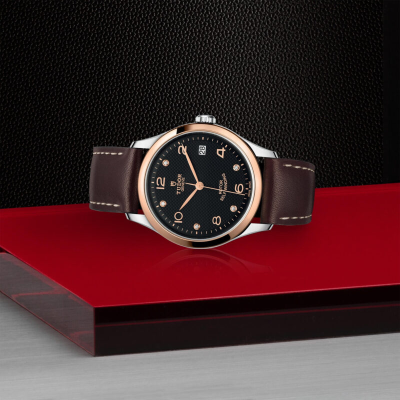 A M91451-0008 watch sitting on a red surface.