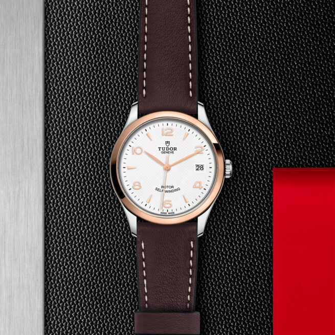 A watch with a M91451-0010 leather strap on a red background.