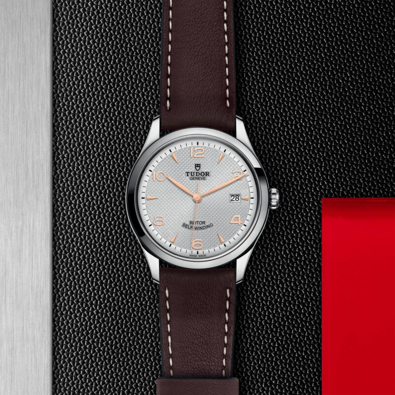 A M91550-0006 with a brown leather strap on a black background.