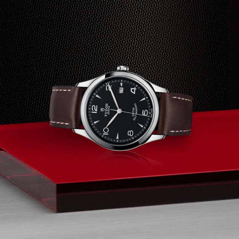 A M91550-0008 watch sitting on a red table.