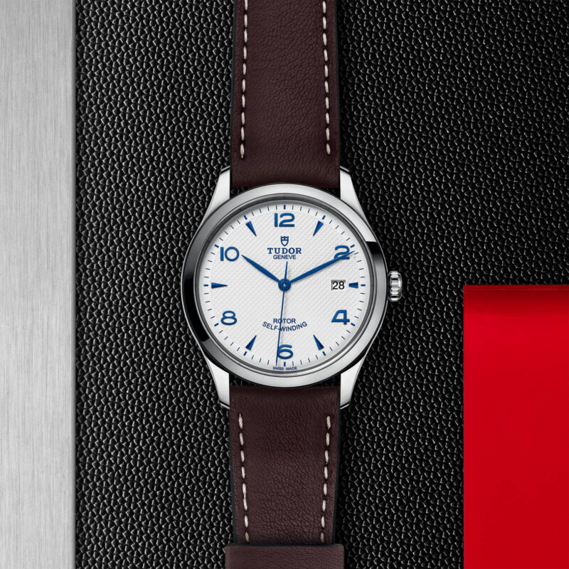 A M91550-0010 with a brown leather strap on a black background.