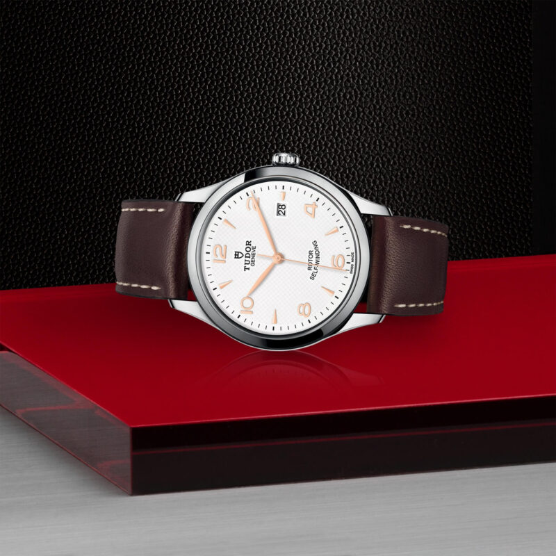 A M91550-0012 watch on a red surface.