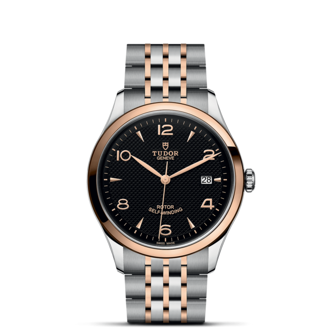 A black and rose gold watch on a black background.