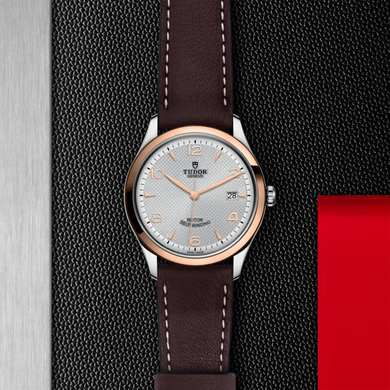 A watch with a M91551-0005 leather strap on a red background.