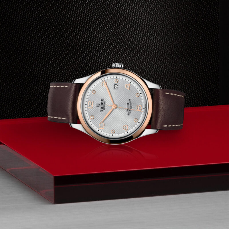 A watch with brown leather straps on a red surface. (Product Name: M91551-0006)