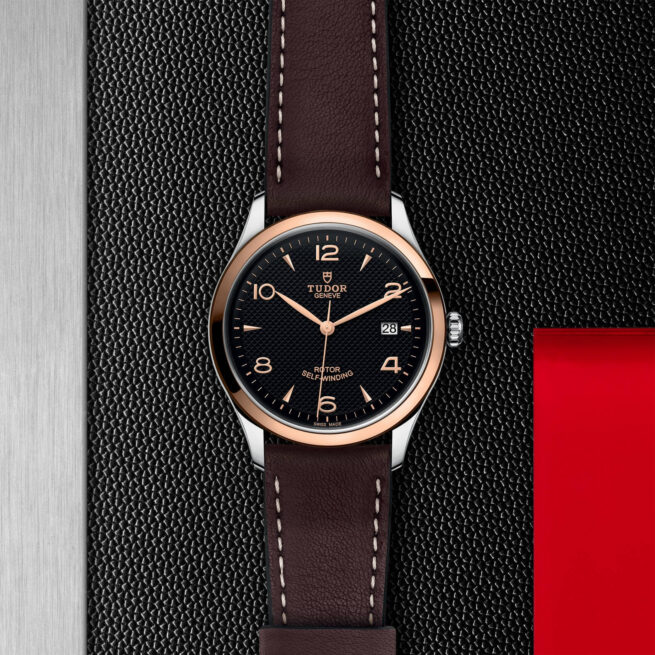 A black and brown M91551-0007 on a red leather strap.