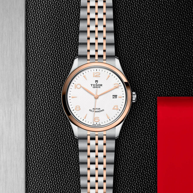 A M91551-0009 with a rose gold and silver dial on a black background.