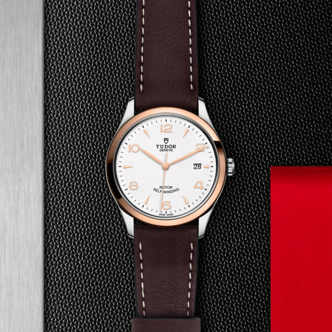 A M91551-0010 with a brown leather strap and a white dial.